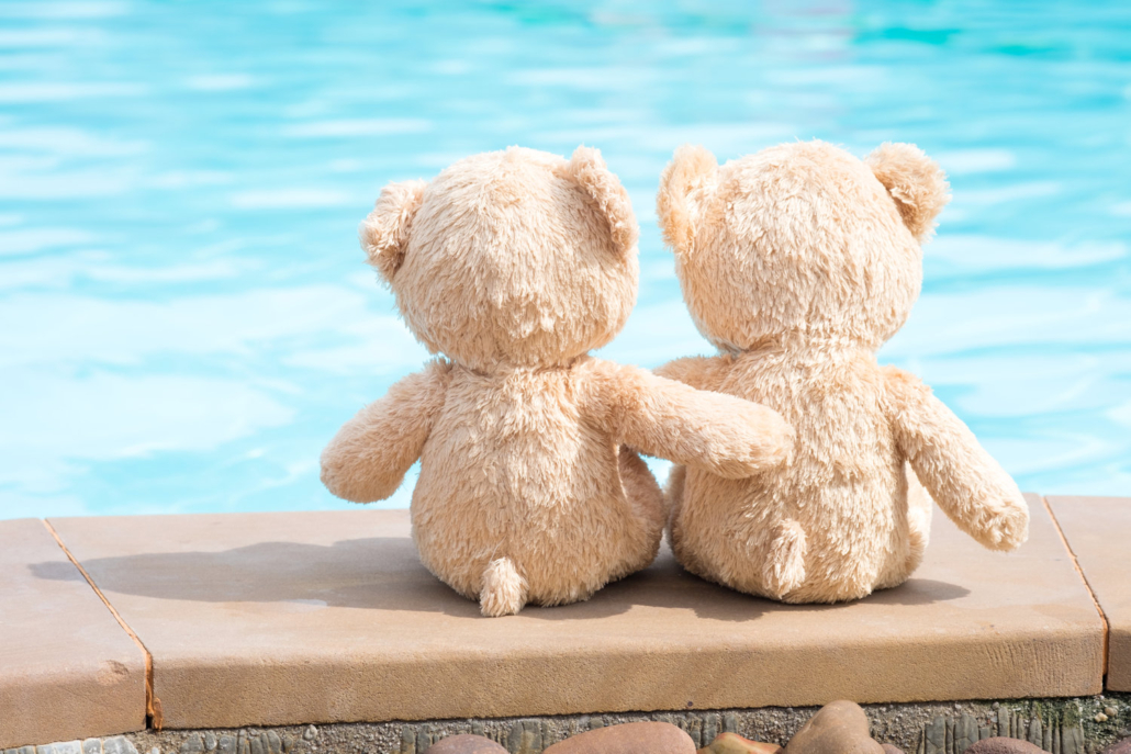 Two teddy bears pool edge view. Love and relationship concept.